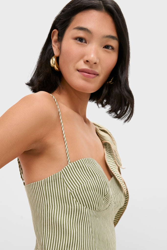 Young woman in a Green Striped Monsterea Leaf Sleeveless Midi Dress with gold hoop earrings, embodying a classic, effortless style. The dress's design is fun and high-end.