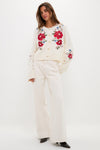 Model wearing the Cream Flowers Embroidered Knit Cardigan, a classic, high-end piece with effortless floral embroidery, paired with fun, wide-leg trousers and dark shoes.