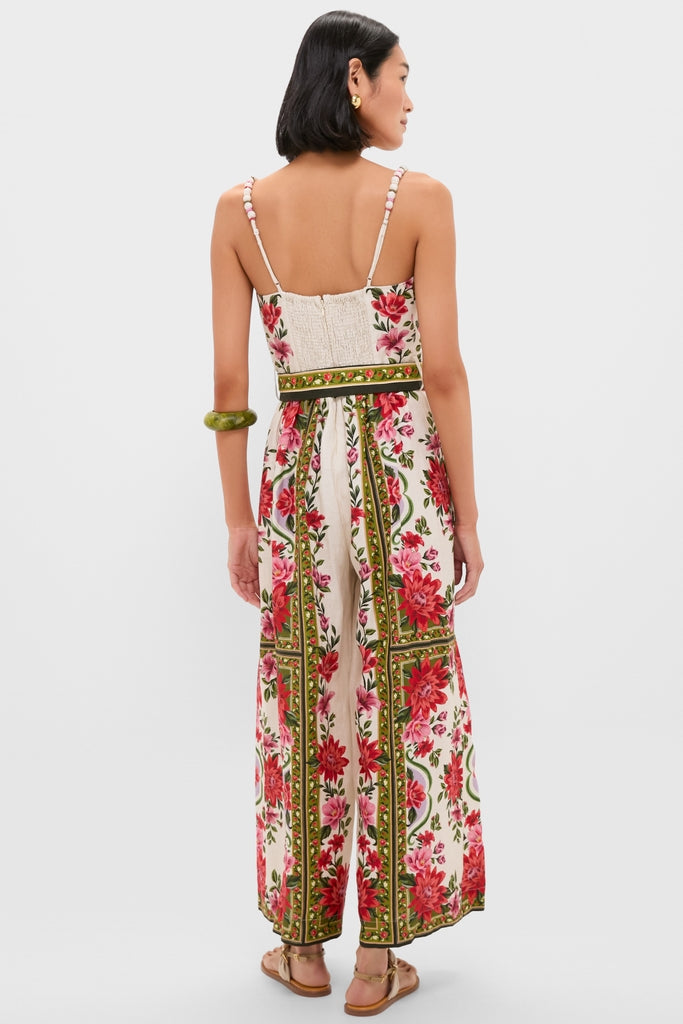 Woman models the Wonder Rio Sand Sleeveless Maxi Jumpsuit with a vibrant floral print, beaded straps, and a smocked bodice, embodying classic, effortless, and high-end style.