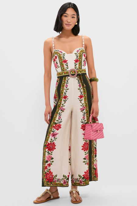 Model wearing the classic Wonder Rio Sand Sleeveless Maxi Jumpsuit with floral panels, beaded straps, and a matching belt, styled with fun, high-end accessories.