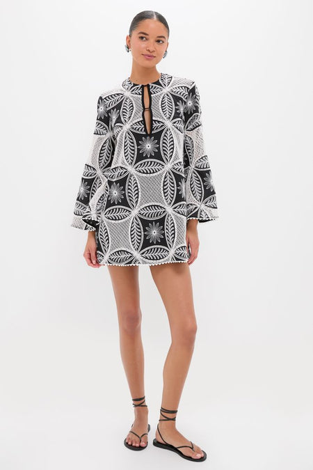 Young woman models the Black Plain Gia Mini Dress, a classic, high-end piece with an effortless, fun floral lace pattern, bell sleeves, and scalloped hem.