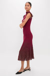 Model wearing the Plum Shimmer Knit Midi Dress, a classic, high-end piece with ruffled shoulders and a pleated hem, styled effortlessly with gold accessories and kitten-heel flats.