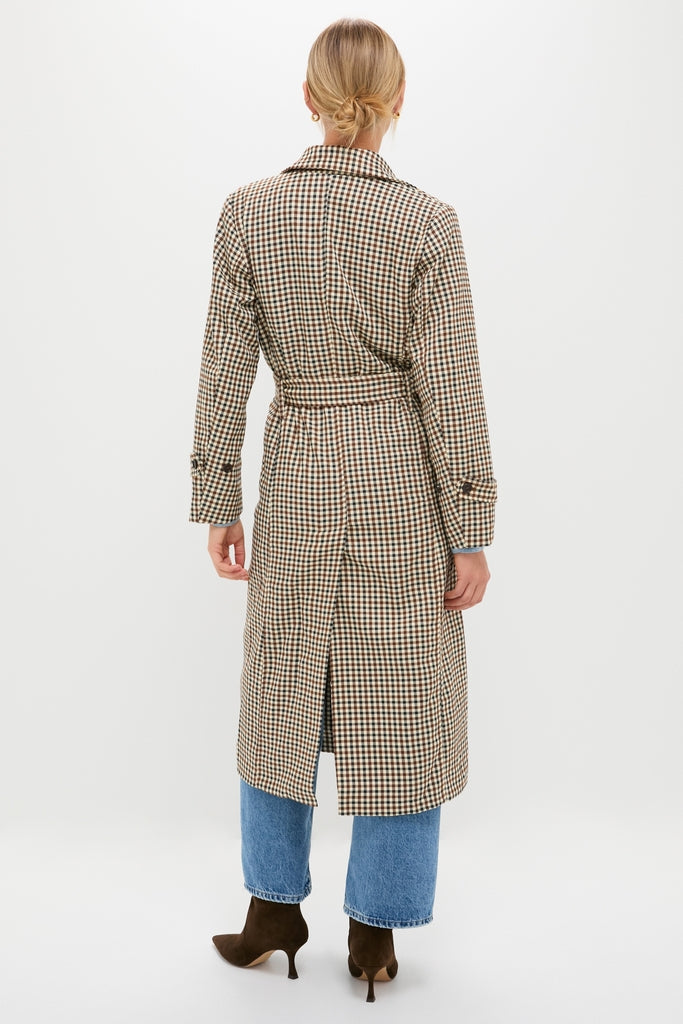 Person showcasing a classic Brown Plaid Long Trench Coat with a belted waist, epitomizing effortless style, paired with blue jeans and dark brown suede heeled boots.