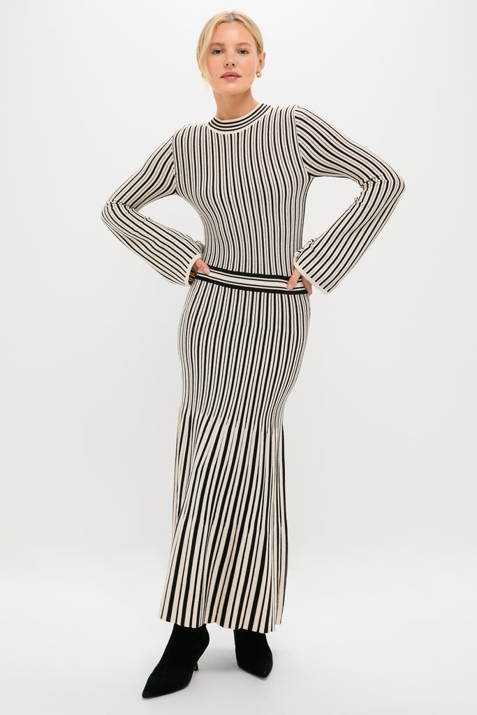Black and Ivory Striped Maxi Dress, featuring a classic, form-fitting design with long sleeves and an ankle-length skirt, exudes effortless, high-end style. Paired with pointed-toe black ankle boots.