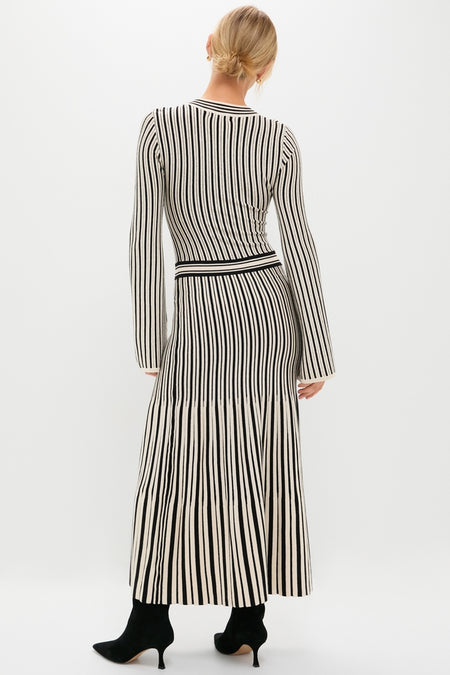 Woman in a Black and Ivory Striped Maxi Dress, a classic, effortless knit ensemble with a high-end, fun twist, featuring a form-fitting top and floor-skimming skirt.