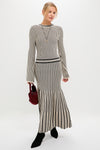 Model wearing the Black and Ivory Striped Maxi Dress, featuring a classic ribbed, long-sleeve top and flared skirt, styled with an effortless, high-end touch.