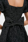 Black Jacquard Mini Dress with puffed sleeves and a large bow detail at the waist, exuding classic and effortless high-end style with a fun twist.