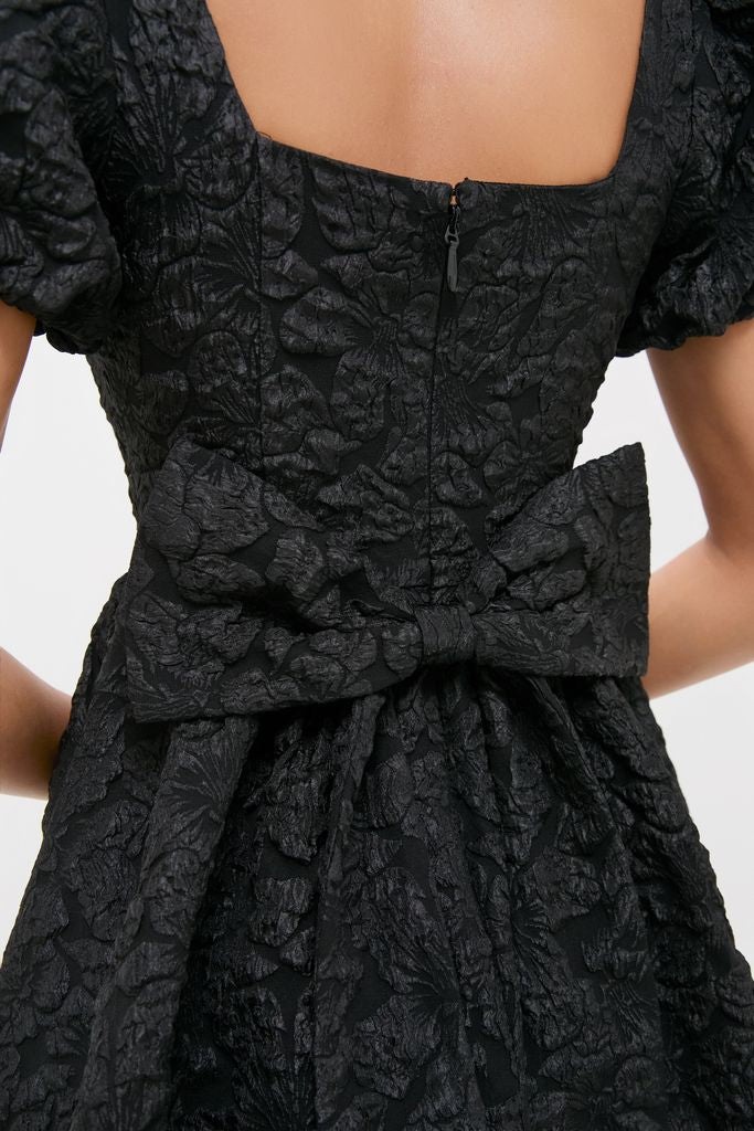 Black Jacquard Mini Dress with puffed sleeves and a large bow detail at the waist, exuding classic and effortless high-end style with a fun twist.