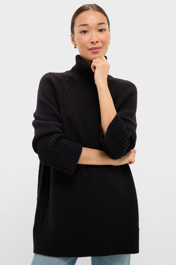 Woman in classic Navy Louisa Turtleneck Sweater, showcasing effortless style with ribbed finishes and side cable-knit details, paired with light-wash jeans for a high-end, fun look.