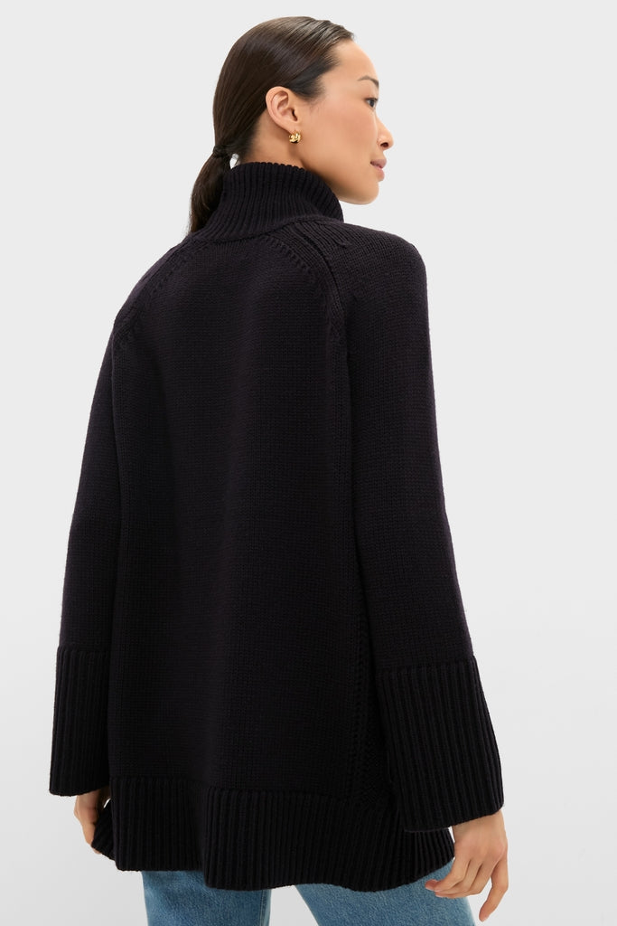 Back view of the Navy Louisa Turtleneck Sweater, showcasing its classic loose fit, effortless ribbed finishes, and high-end side cable-knit detailing, embodying Tuckernuck's fun sophistication.