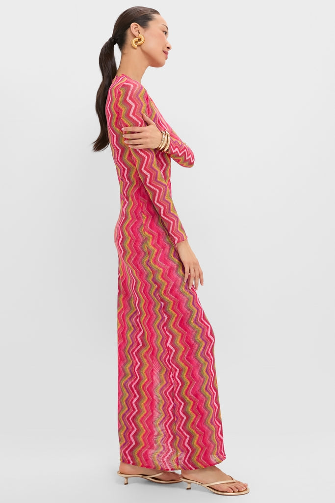 Woman in profile wearing the Electric Wave Pink Scarlet Maxi Dress—a classic, effortless knit with a bold chevron pattern, paired with gold accessories for a fun, high-end look.