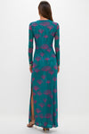 Woman in a classic, teal Jade Ginkgo Scarlet Maxi Dress with abstract motifs, featuring a high side slit. An effortless, high-end look paired with strappy heels.