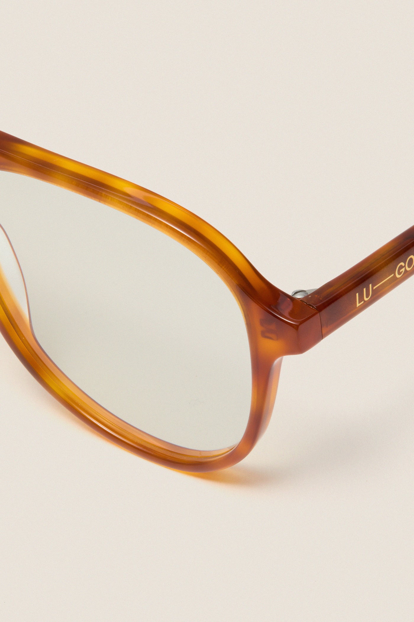 Maple Blue Light Scout Glasses: Classic amber tortoiseshell aviator frames with clear lenses and gold branding, offering a fun, high-end look for effortless, everyday style.