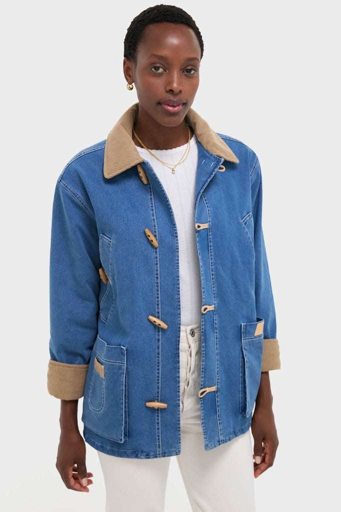 Indigo Barn Jacket modeled, featuring a classic blue denim design with wooden toggle closures, tan corduroy accents, and white stitching, embodying effortless, high-end style.