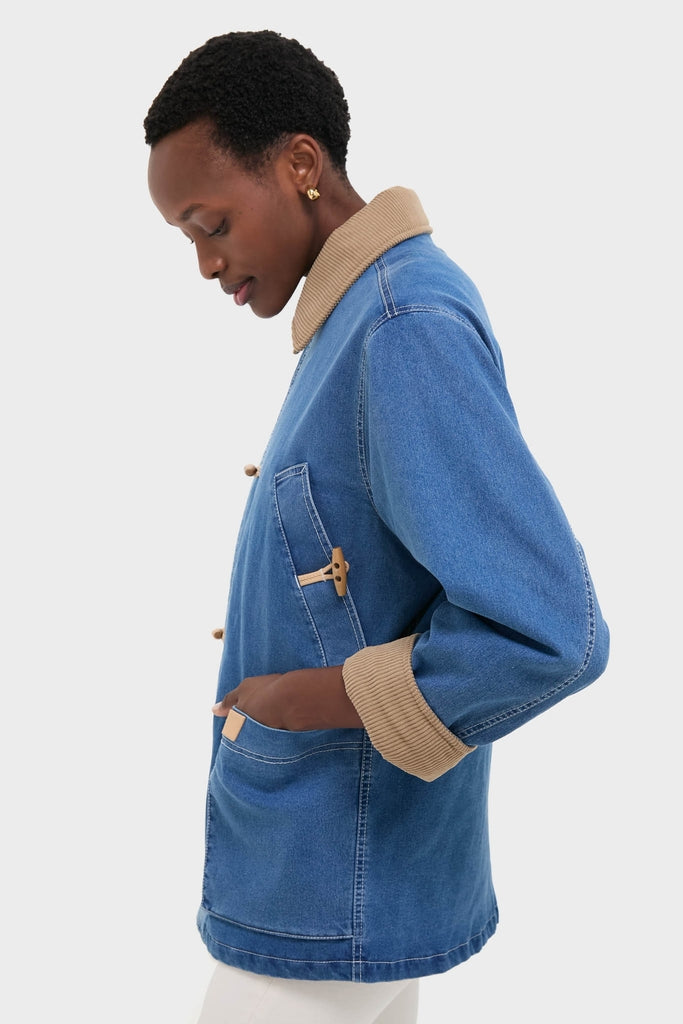 Model wearing the Indigo Barn Jacket, a classic, high-end denim piece with a tan corduroy collar and toggle buttons, exuding effortless fun and sophistication.