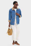 Model in classic Indigo Barn Jacket with a tan corduroy collar, styled effortlessly with white jeans and a suede bucket bag, exuding high-end, fun sophistication.