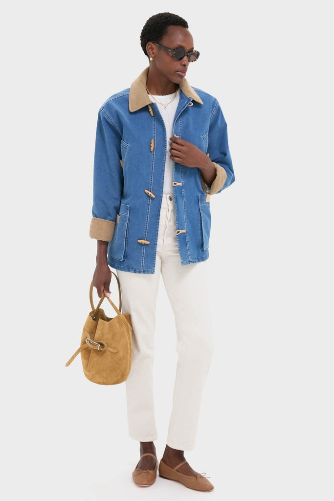 Model in classic Indigo Barn Jacket with a tan corduroy collar, styled effortlessly with white jeans and a suede bucket bag, exuding high-end, fun sophistication.
