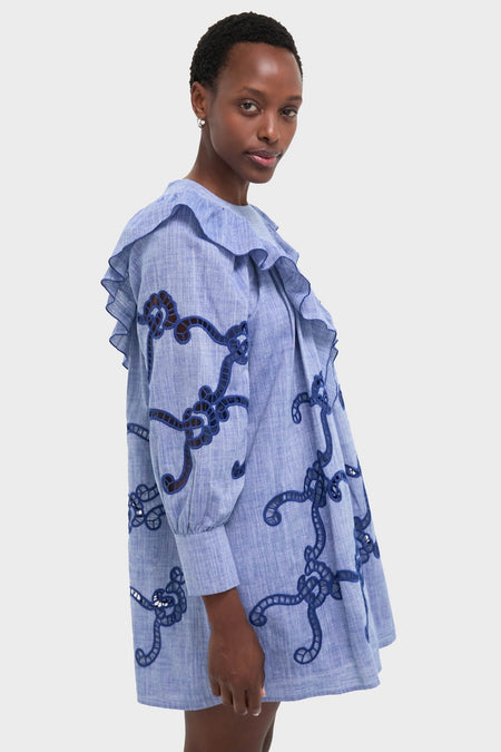 Model wearing the classic Seabank Chambray Azalea Dress, featuring effortless navy rope-knot embroidery, ruffled yoke, and a fun, high-end flared skirt.