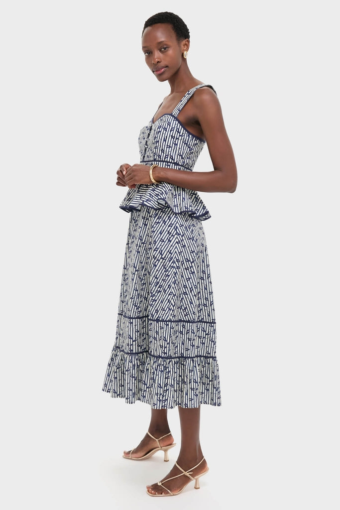 Model in classic, high-end Vine Stripe Lacey Dress; a navy-and-white abstract print bustier top with peplum and matching midi skirt. Effortless, fun elegance.