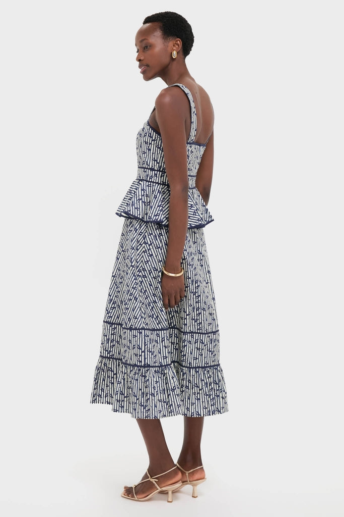 Woman modeling the Vine Stripe Lacey Dress, a classic two-piece style with a doodle pattern, sleeveless top, and tiered midi skirt, embodying effortless high-end fashion.