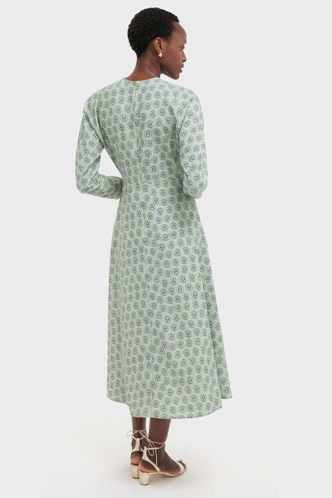 Woman in a Navy Bird Block Vika Dress, showcasing a classic, effortless style with a fitted bodice and flared hem, paired with light-colored, block-heeled sandals.