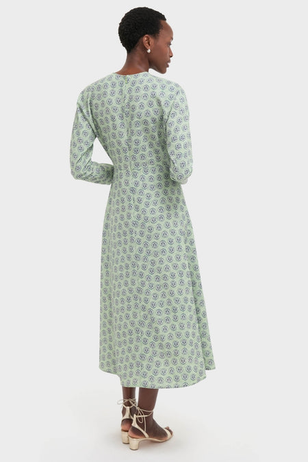 Woman in a Navy Bird Block Vika Dress, showcasing a classic, effortless style with a fitted bodice and flared hem, paired with light-colored, block-heeled sandals.