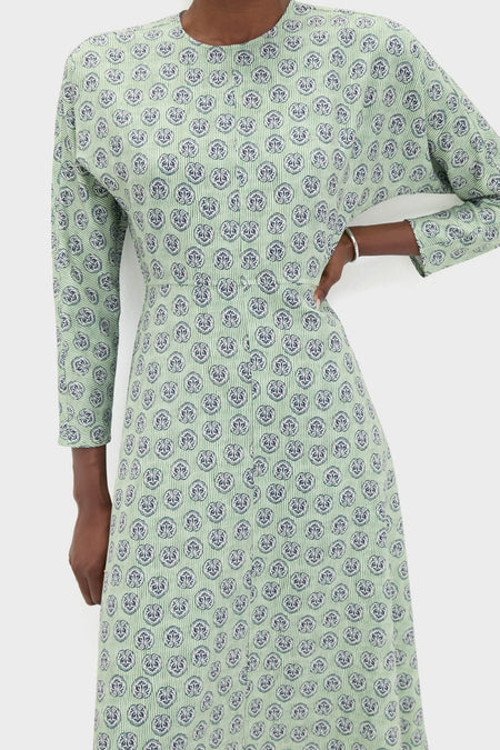 Person wearing the Navy Bird Block Vika Dress, featuring a classic, ankle-length design with effortless navy motifs and a fun silver bangle, embodying high-end style.