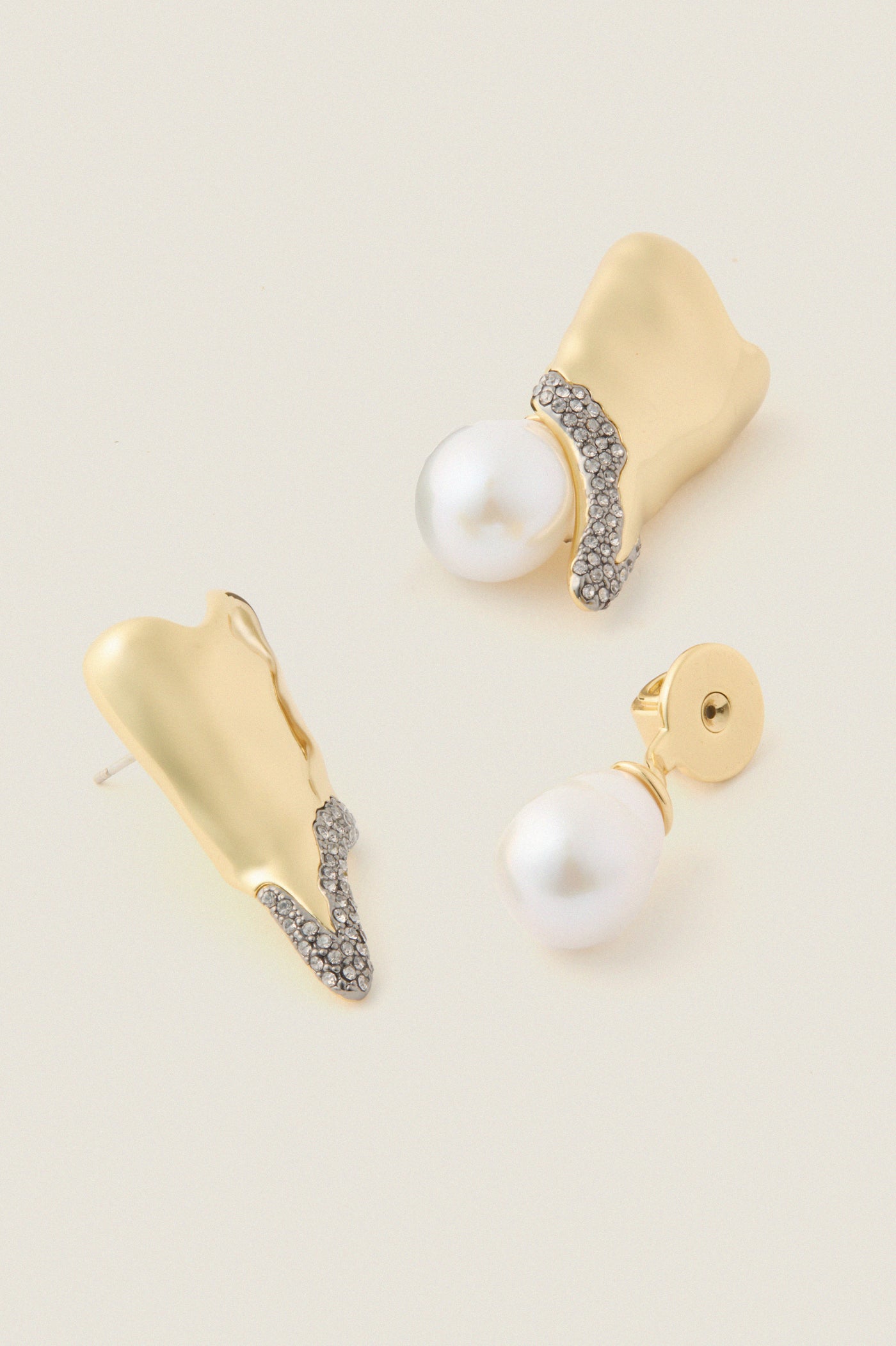Gold and Pearl Spencer Earrings showcase classic elegance with abstract gold forms, pavé crystals, and baroque pearl drops, embodying effortless, high-end style for fun, special occasions.