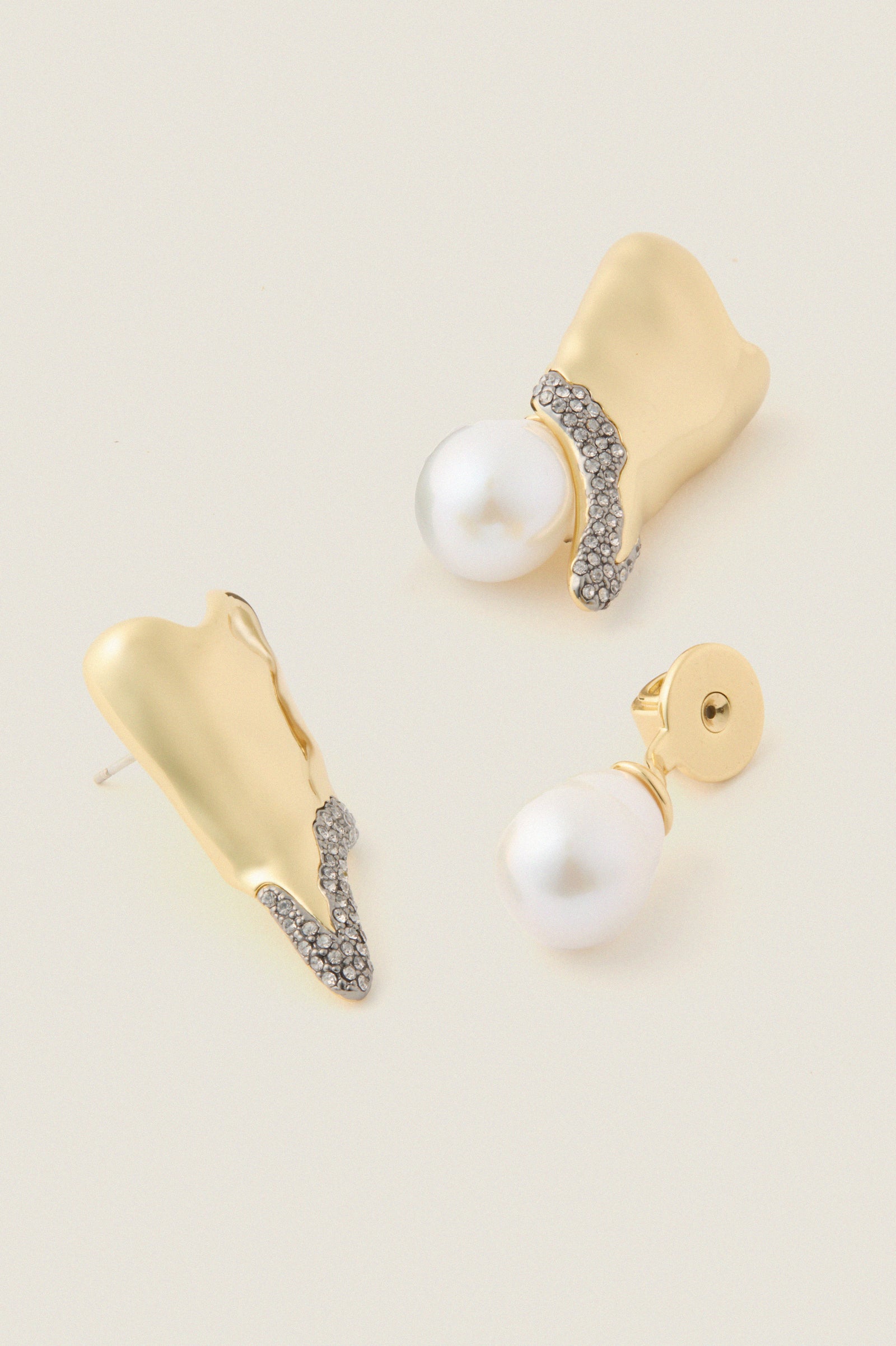 Gold and Pearl Spencer Earrings showcase classic elegance with abstract gold forms, pavé crystals, and baroque pearl drops, embodying effortless, high-end style for fun, special occasions.