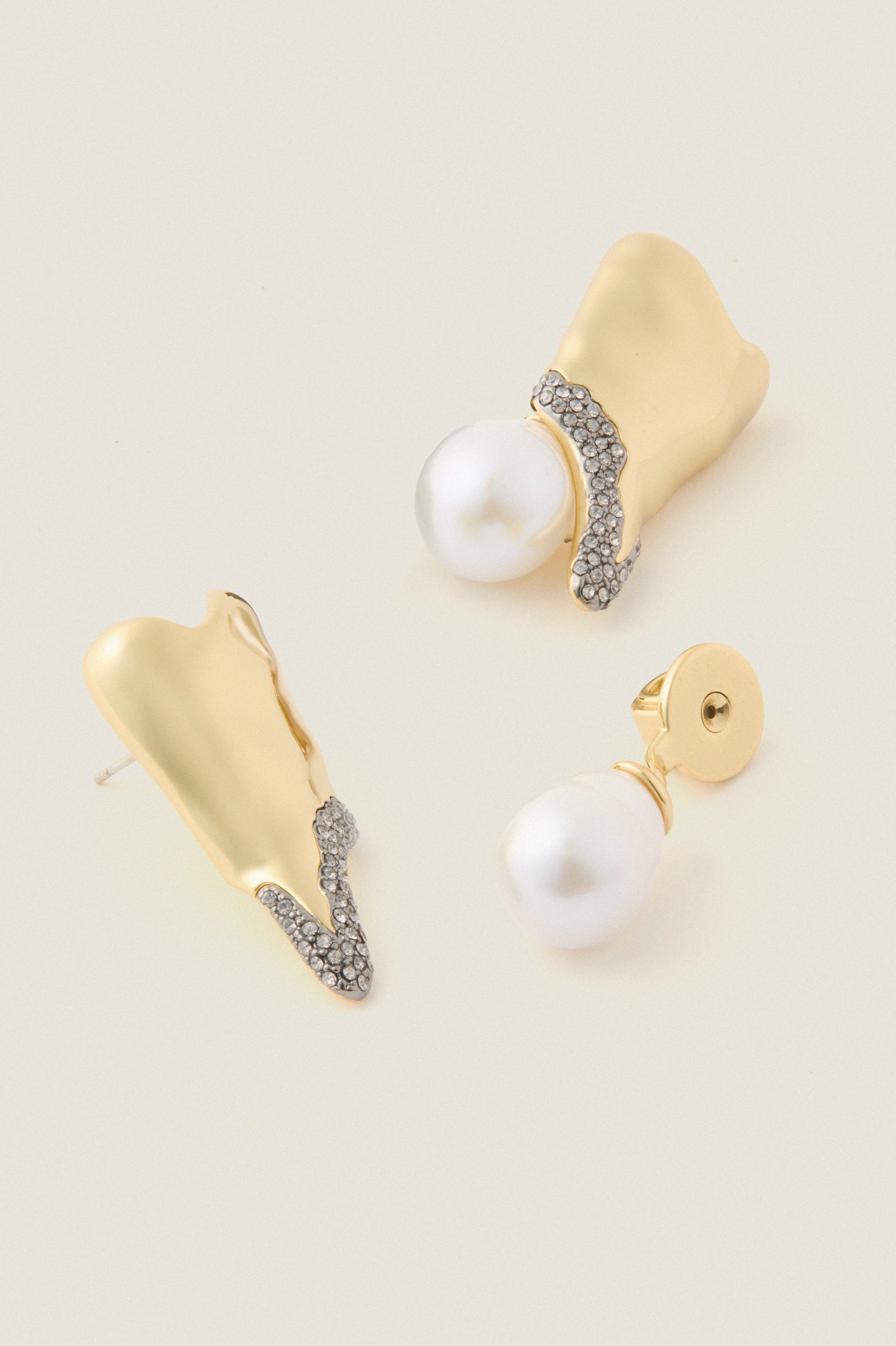 Gold and Pearl Spencer Earrings showcase classic elegance with abstract gold forms, pavé crystals, and baroque pearl drops, embodying effortless, high-end style for fun, special occasions.