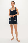 Model wearing Navy Mini Terrycloth Button Tank Dress with contrast trim, square neckline, and front pockets. Paired with gold jewelry and white sandals, exuding classic, effortless, high-end style.