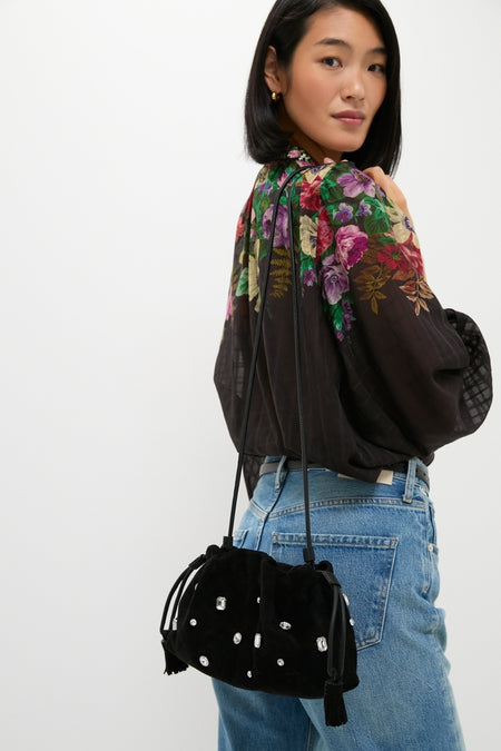 Young woman with a classic, high-end look carries the Black Small Crystal Stash Bag, featuring crystal-like studs and tassel cords, adding effortless fun to her ensemble.