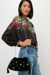 Woman wearing an effortless, high-end Black Small Crystal Stash Bag with rhinestone details and chain strap, complementing a classic floral blouse and jeans ensemble.