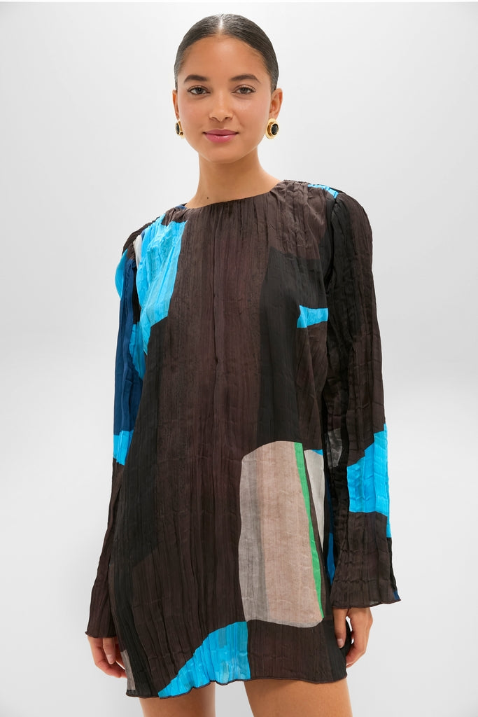 Woman modeling classic Blue Prism Kona Dress, a fun, high-end mini with a crinkled, abstract pattern and straight silhouette, exuding effortless elegance.