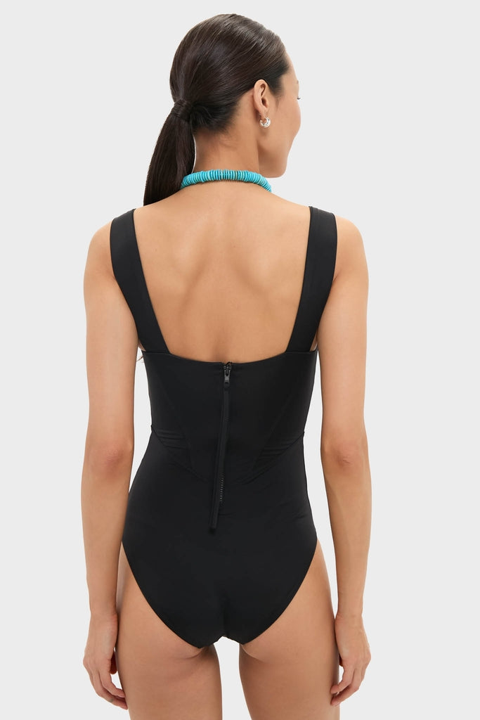 Back view of a woman in a classic, high-end Black Adelaide One Piece swimsuit with a zipper and wide straps, paired with an effortless, fun turquoise necklace.