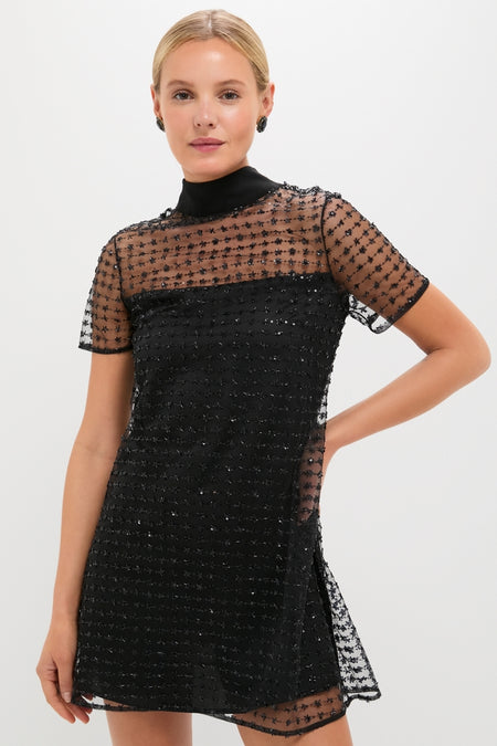 Stardust Onyx Ilana Dress: A classic, high-end mini with effortless charm, featuring a mock neck, sheer embellished tulle overlay, and self-tie bow. Perfect for festive fun.
