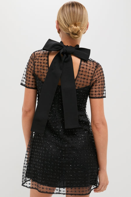 Stardust Onyx Ilana Dress featuring a sheer, star-embellished tulle overlay, classic self-tie bow, and effortless back cut-out, exudes high-end, fun elegance.