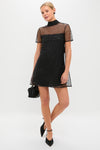 Stardust Onyx Ilana Dress: A classic, effortless mini with a high neck, sheer embellished tulle, and back cut-out. Paired with a chic black pouch and heels.