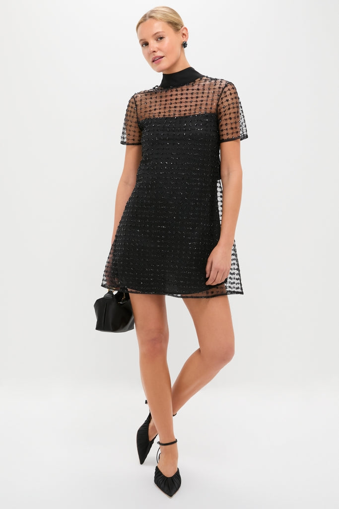 Stardust Onyx Ilana Dress: A classic, effortless mini with a high neck, sheer embellished tulle, and back cut-out. Paired with a chic black pouch and heels.