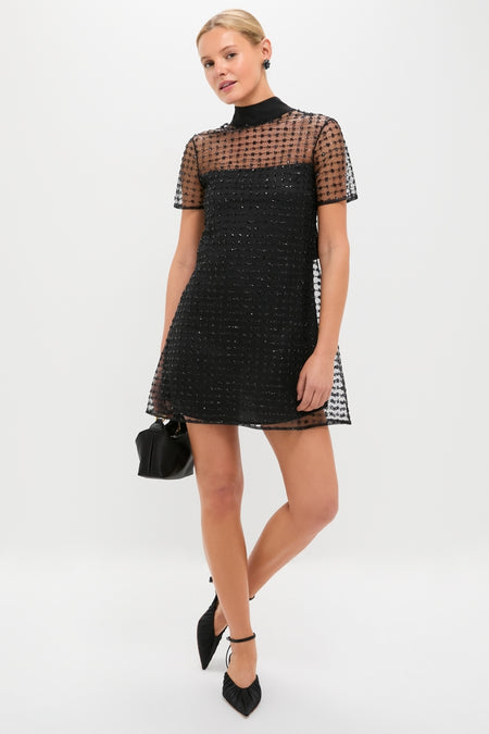 Stardust Onyx Ilana Dress: A classic, effortless mini with a high neck, sheer embellished tulle, and back cut-out. Paired with a chic black pouch and heels.