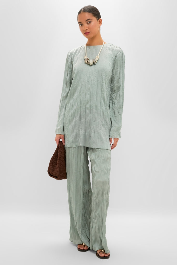 Model in a classic, effortless Silver Sage Kona Dress, a high-end, textured ensemble with a straight silhouette, styled with a chunky necklace and woven handbag.