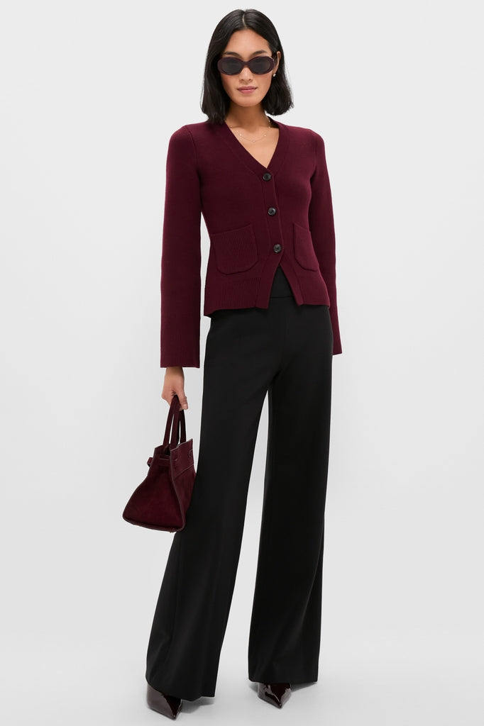 Woman models classic Black Kalinda Pant with wide-leg design, high waistband, and pressed crease, paired effortlessly with a burgundy cardigan and accessories for a high-end, fun look.