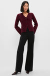 Woman in a deep burgundy cardigan and classic Black Kalinda Pant, featuring an effortless wide-leg silhouette, high waistband, and polished front crease for a fun, high-end look.
