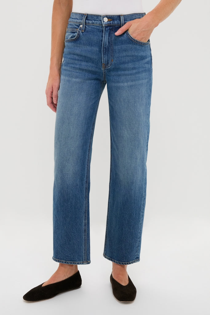 Rebel Blue Harley High Rise Arc Leg jeans showcase a classic, effortless style with a high waist and subtle barrel leg, paired with black flats for a fun, high-end look.