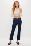 Woman in a fitted beige top with Indigo Rinse Leah Mid Rise Straight Leg jeans, embodying an effortless, classic style with high-end, fun appeal.
