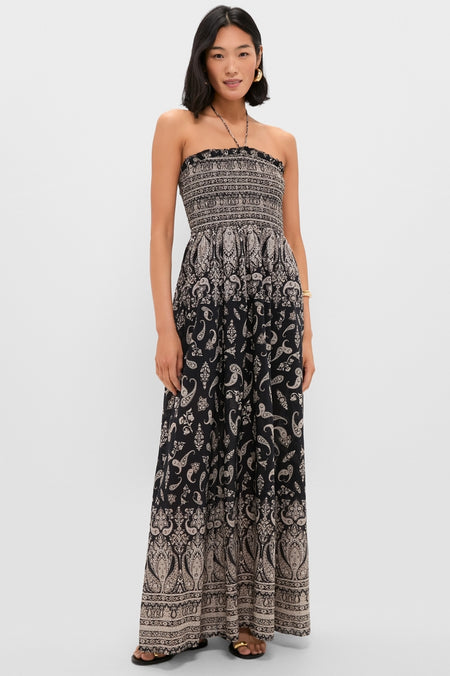 Woman models classic Black Multi Ayanna Dress with smocked bodice and flowing paisley skirt, embodying effortless, fun, high-end style; paired with simple sandals and accessories.