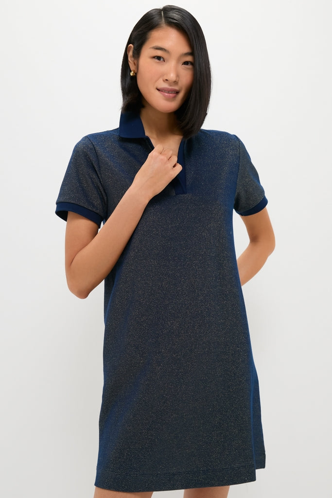 Woman wearing an effortless, high-end Navy Gold Lurex Pique Hutton Dress with a classic collar, smiling gently while showcasing its fun, relaxed fit.