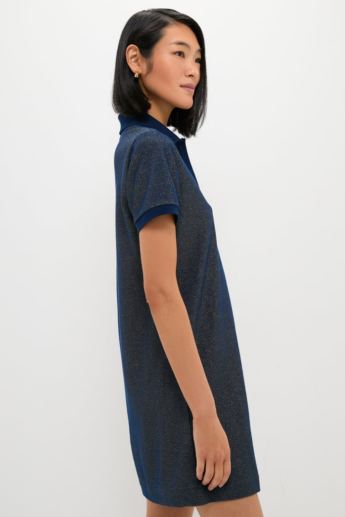 Woman in profile wearing the Navy Gold Lurex Pique Hutton Dress, a classic, effortless polo-style piece, paired with small gold hoop earrings, embodying high-end and fun fashion.