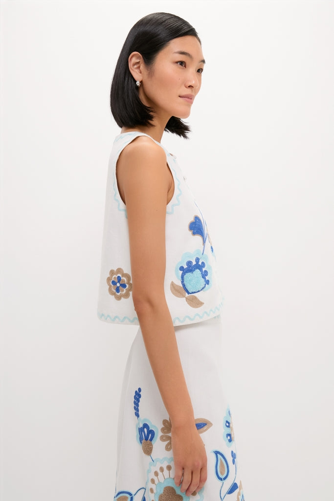 Model in the classic Folk Flower Embroidered Luna Top, showcasing effortless style with fun blue and tan floral embroidery, epitomizing Tuckernuck's high-end, cool fashion ethos.