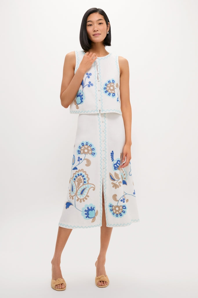Folk Flower Embroidered Sadie Skirt ensemble features a classic, effortless style with fun floral motifs, paired with high-end straw-look sandals for a chic, confident look.